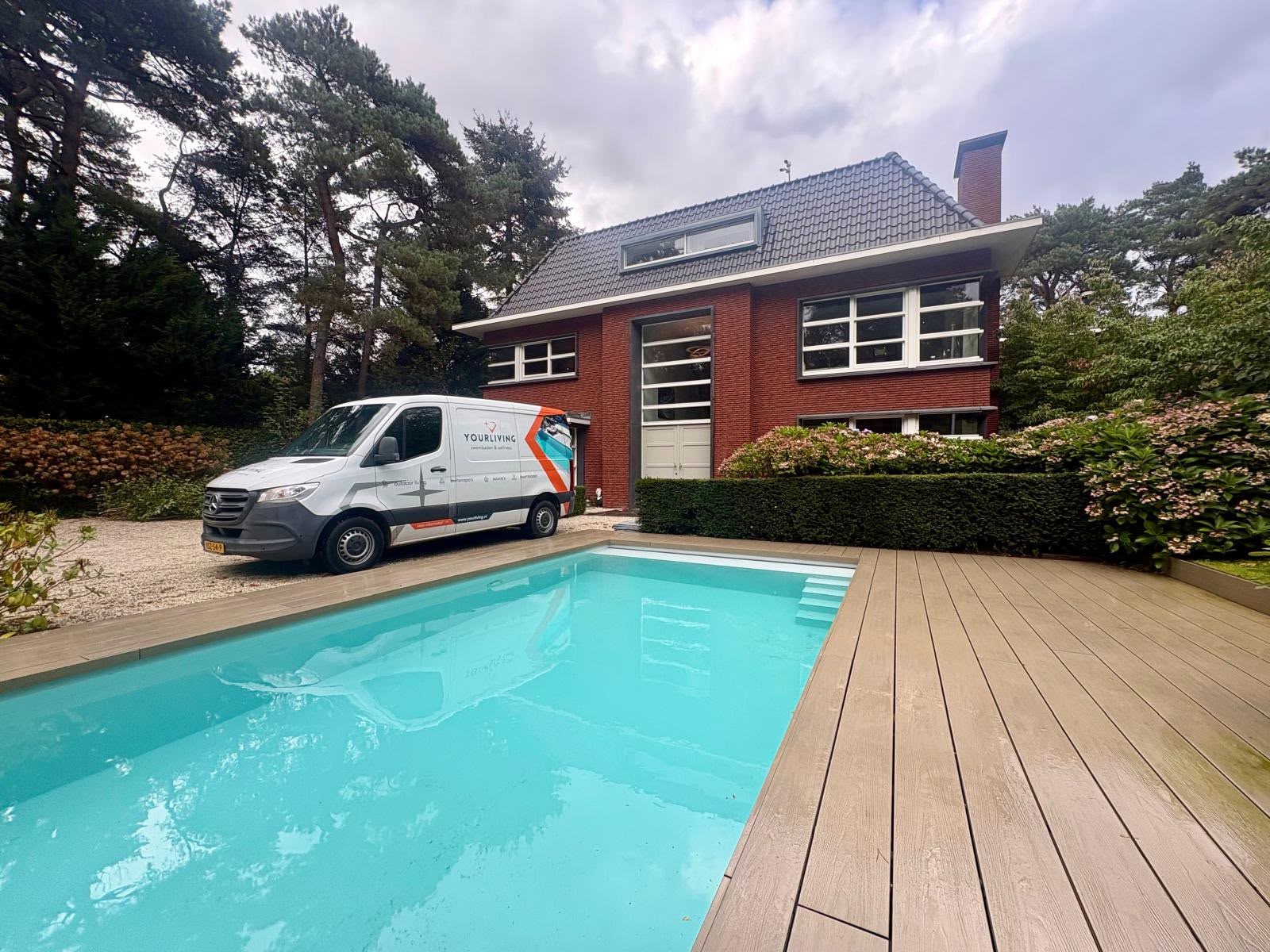 Zwembad met brede instap en terras naast de woning in Bosch en Duin.
