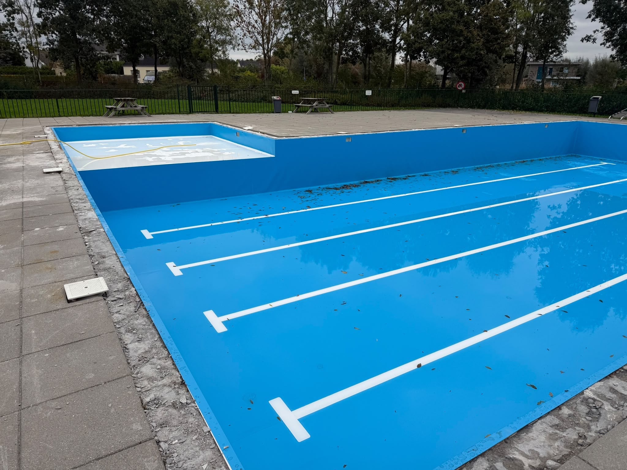 Blauwe zwembadwanden en witte baanmarkering tijdens de renovatie in Zeewolde.