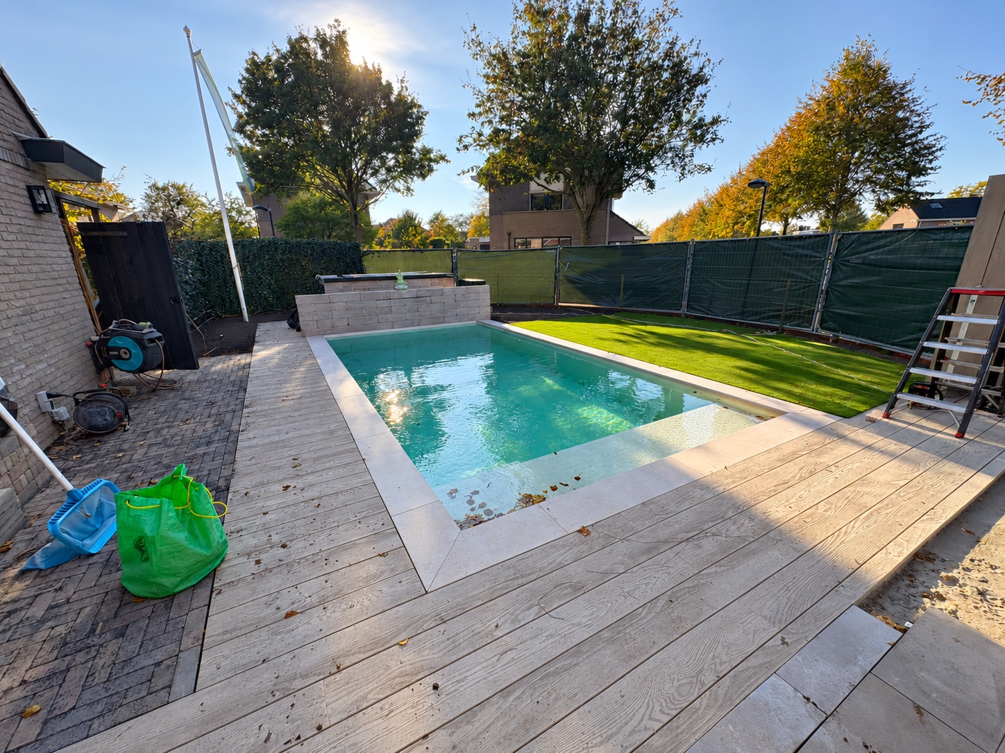 Zwembad met brede instap, lichte randstenen en terras in houtlook in Dronten.