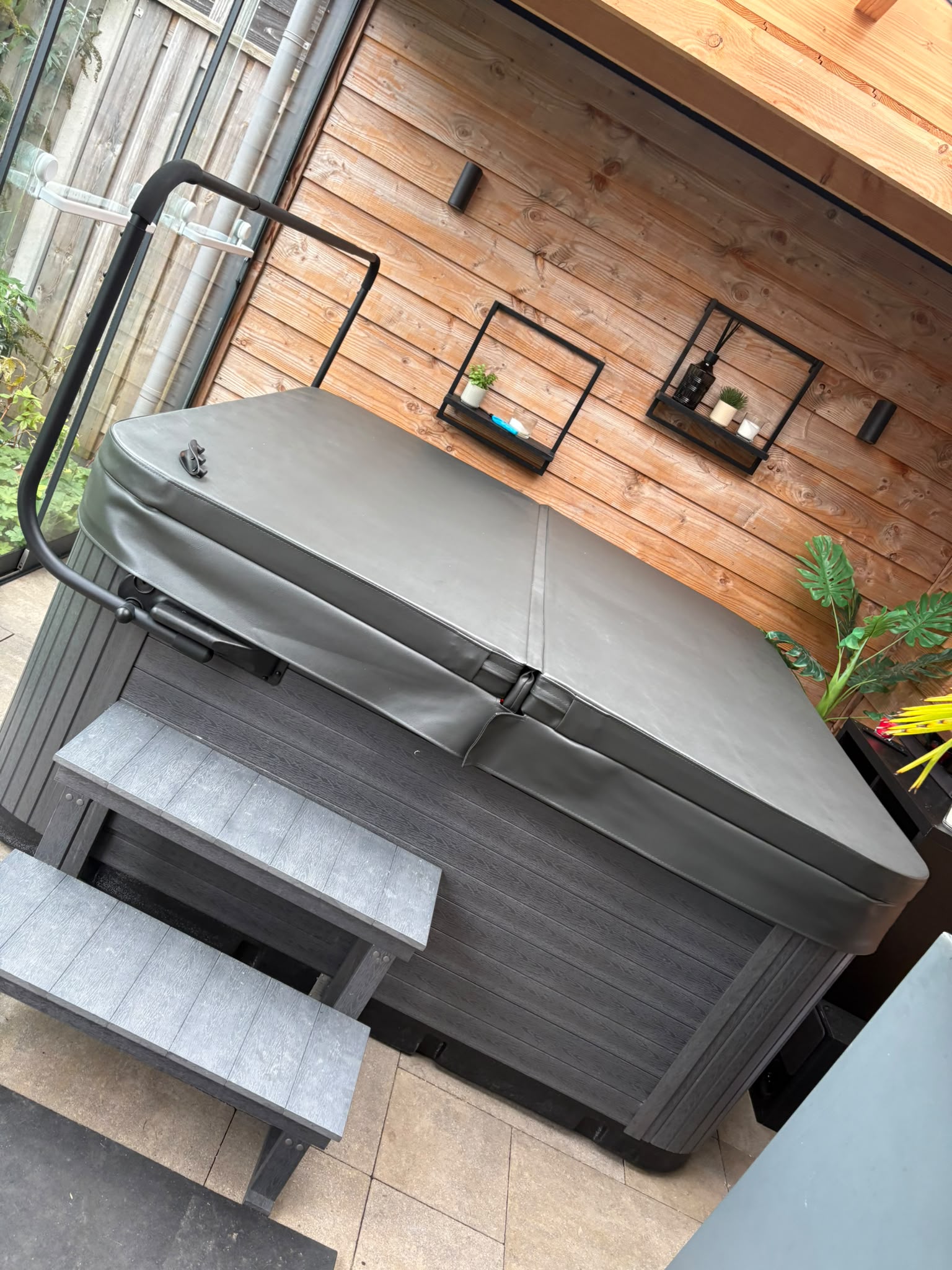 Spa met gesloten afdekking, coverlift en instaptrap onder de overkapping in Biddinghuizen