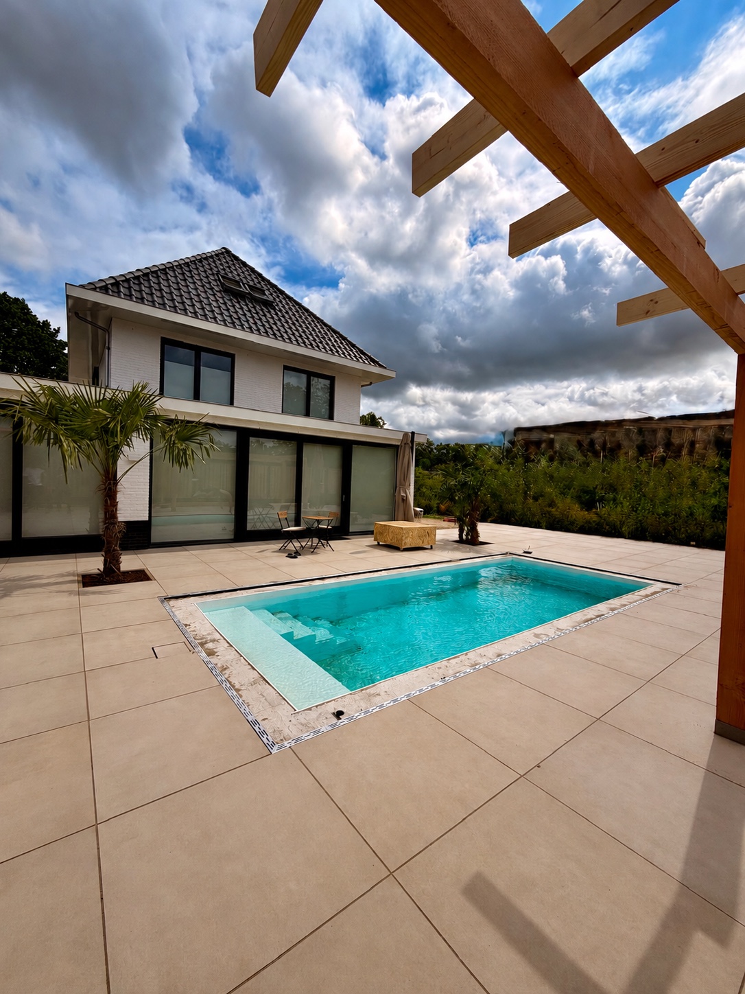 PP-zwembad met plage en trap naast de woning in Zutphen.