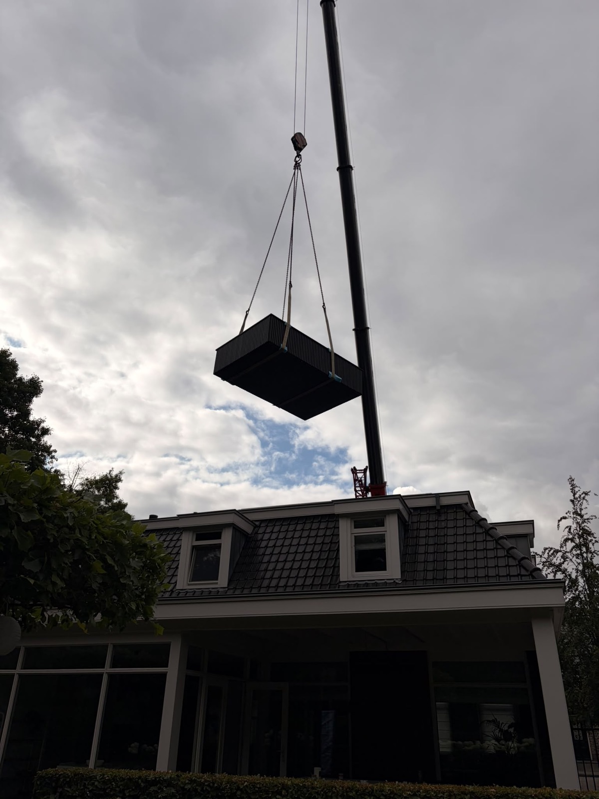De minipool hangt aan de hijskraan boven de woning in Ossendrecht.